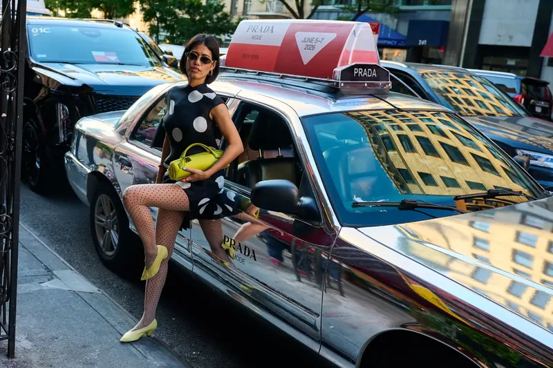 A model poses beside a cab with a luxury brand's static top