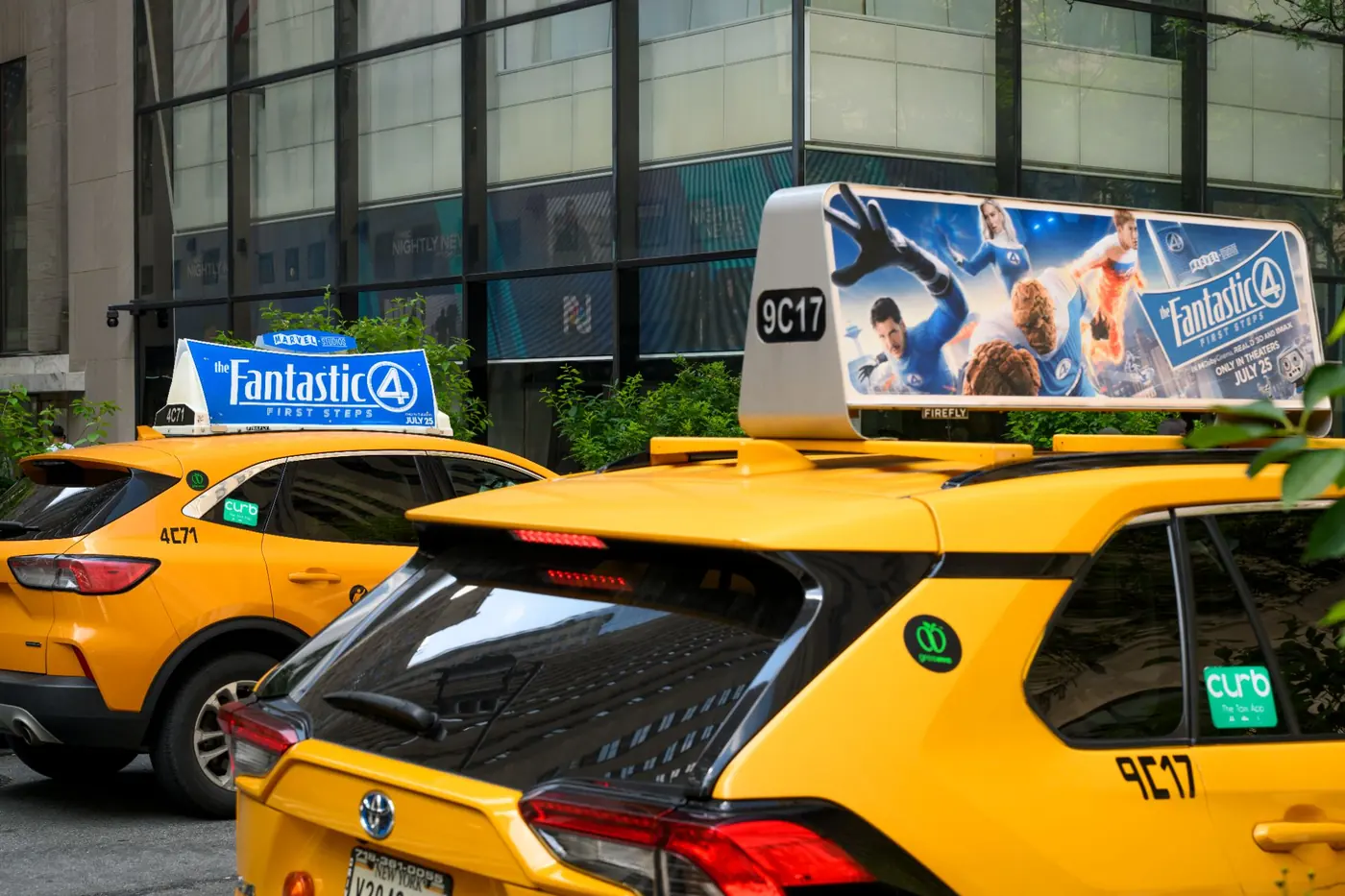 Two yellow cabs with static tops promoting a superhero film